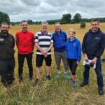 five people standing in a field
