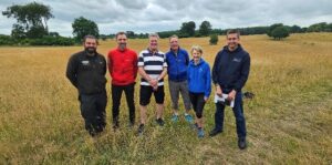 five people standing in a field